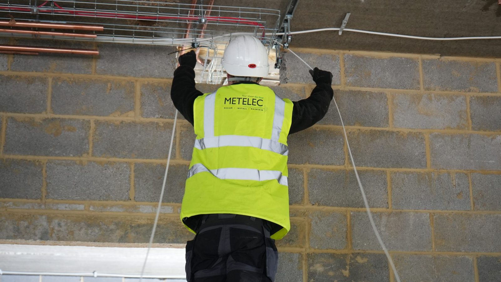 Metelec engineer installing cable along tray at Woodrising luxury residence