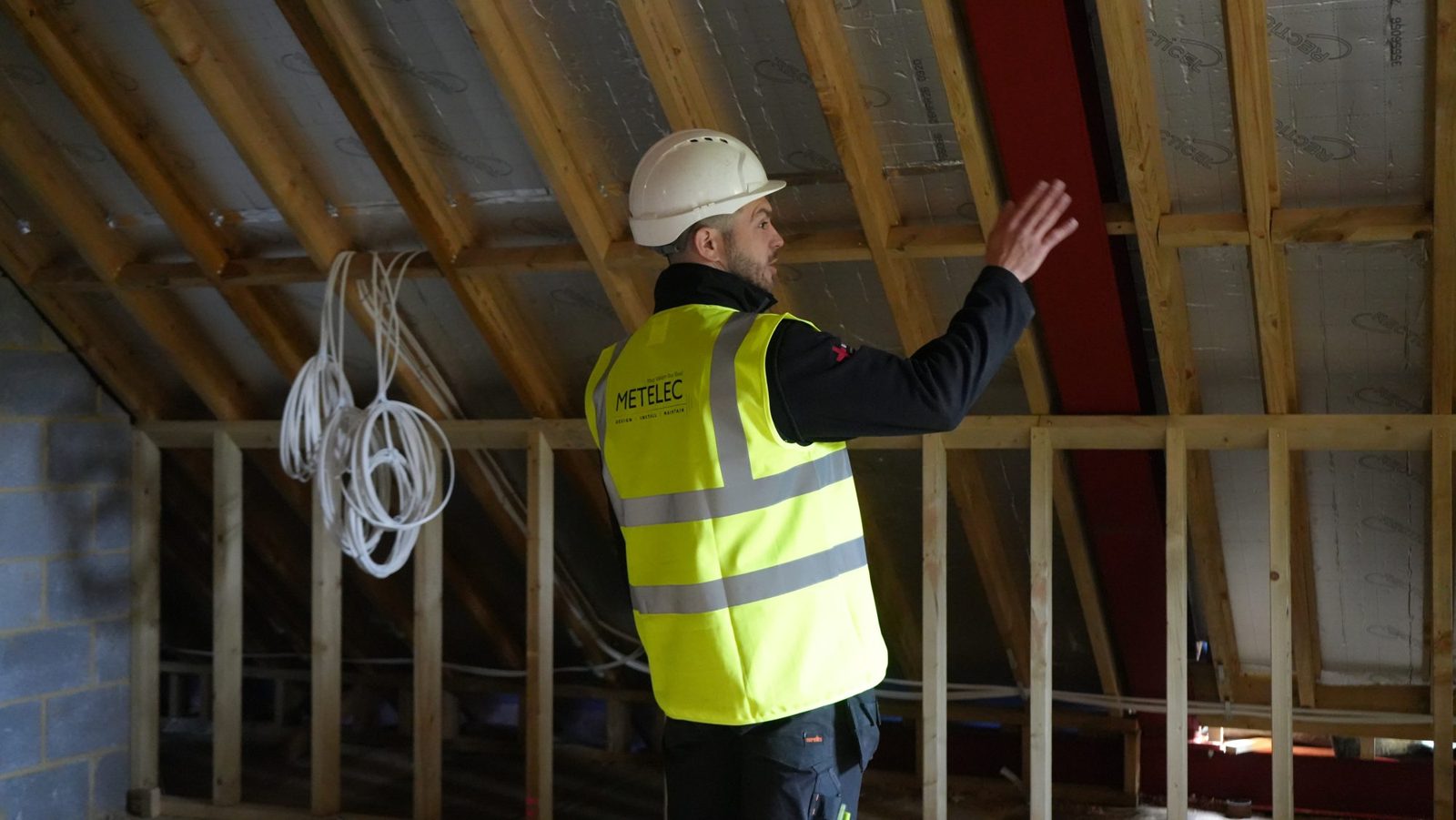 Metelec engineer planning cable routes in the loft at Woodrising